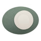 A large oval textured washable paper placemat in green is shown under a white plate.