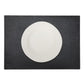 A large rectangular textured washable paper placemat in black is shown under a white plate.