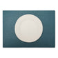 A large rectangular textured washable paper placemat in teal is shown under a white plate.
