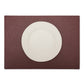 A large rectangular textured washable paper placemat in dark red is shown under a white plate.