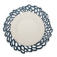 A lace effect washable paper circular placemat is shown in navy, under a white plate.