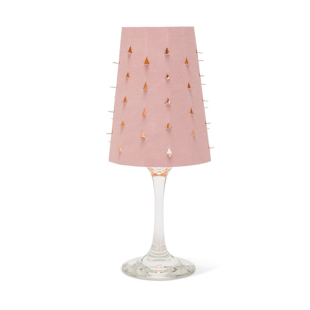 A pink washable paper lampshade with cut out details is shown sitting atop a wine glass.
