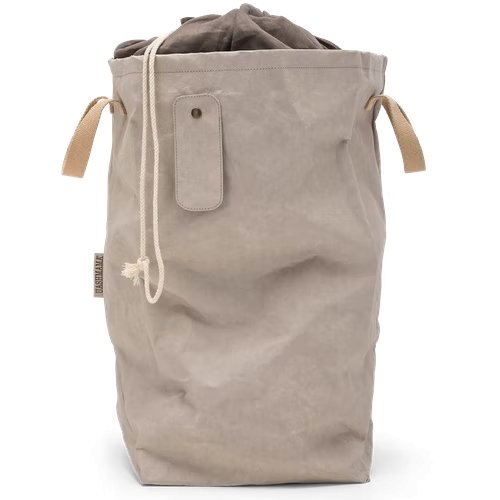 A washable paper laundry bag is shown in grey. It features two side handles, a popper tab, and an interior drawstring lining. 