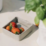 A washable paper tray in grey is shown containing strawberries.