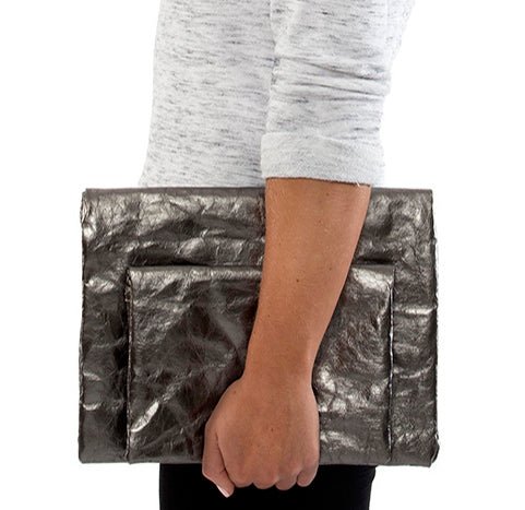 A person is shown holding two metallic pewter washable paper clutches - one large and one small.