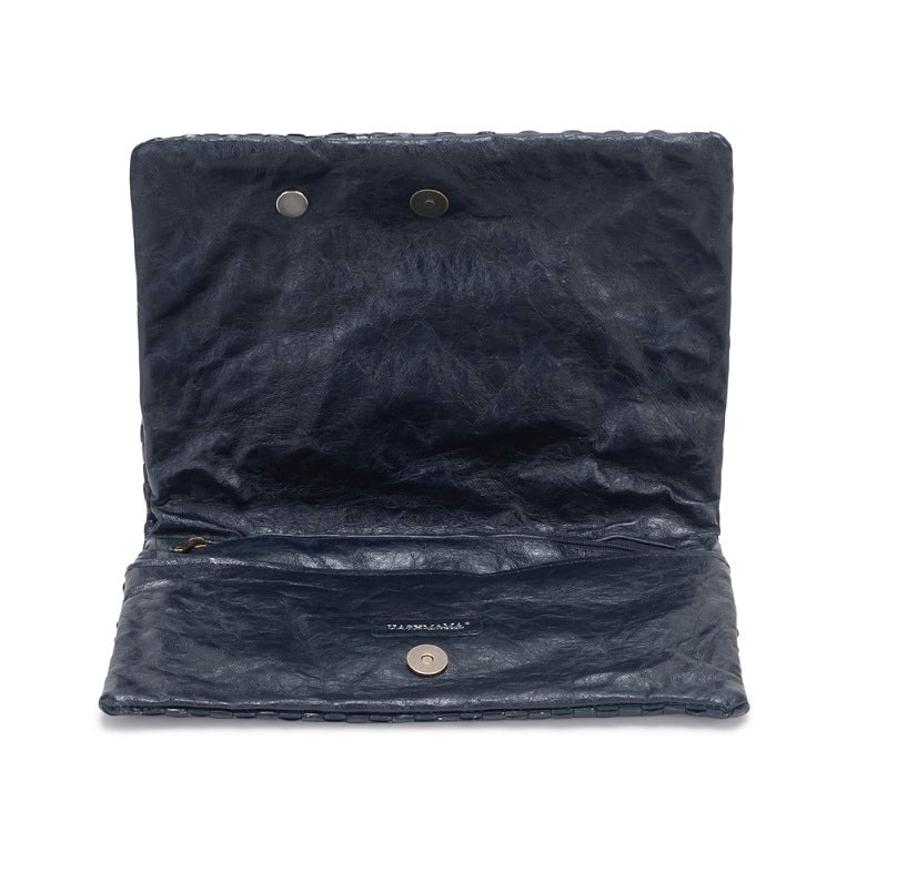 A washable paper folded clutch is shown open in navy, with a metallic stud closure and UASHMAMA logo stamp in silver.
