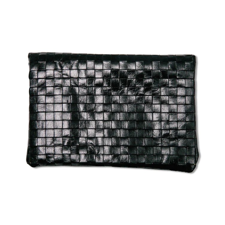 A woven washable paper clutch is shown from the back in navy.