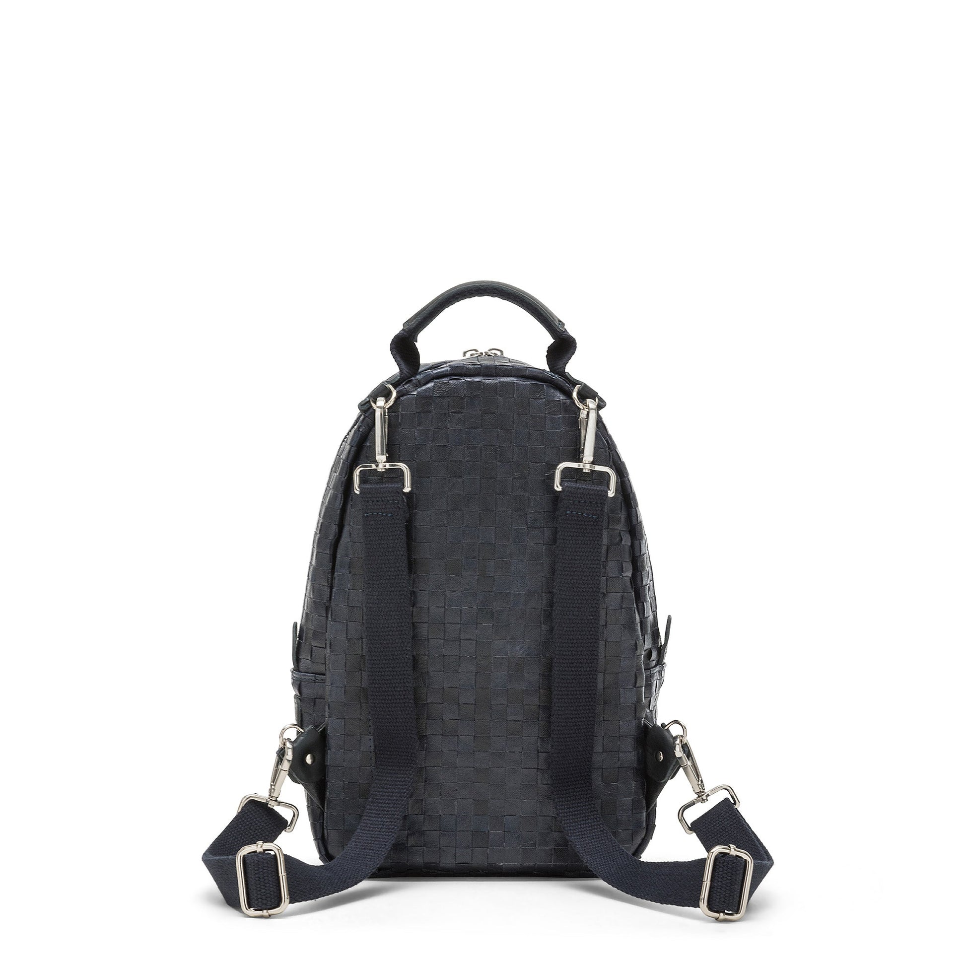 A navy washable paper woven backpack is shown from the back, with a top handle, brass hardware, two long shoulder straps and a gold zip pocket at rear.