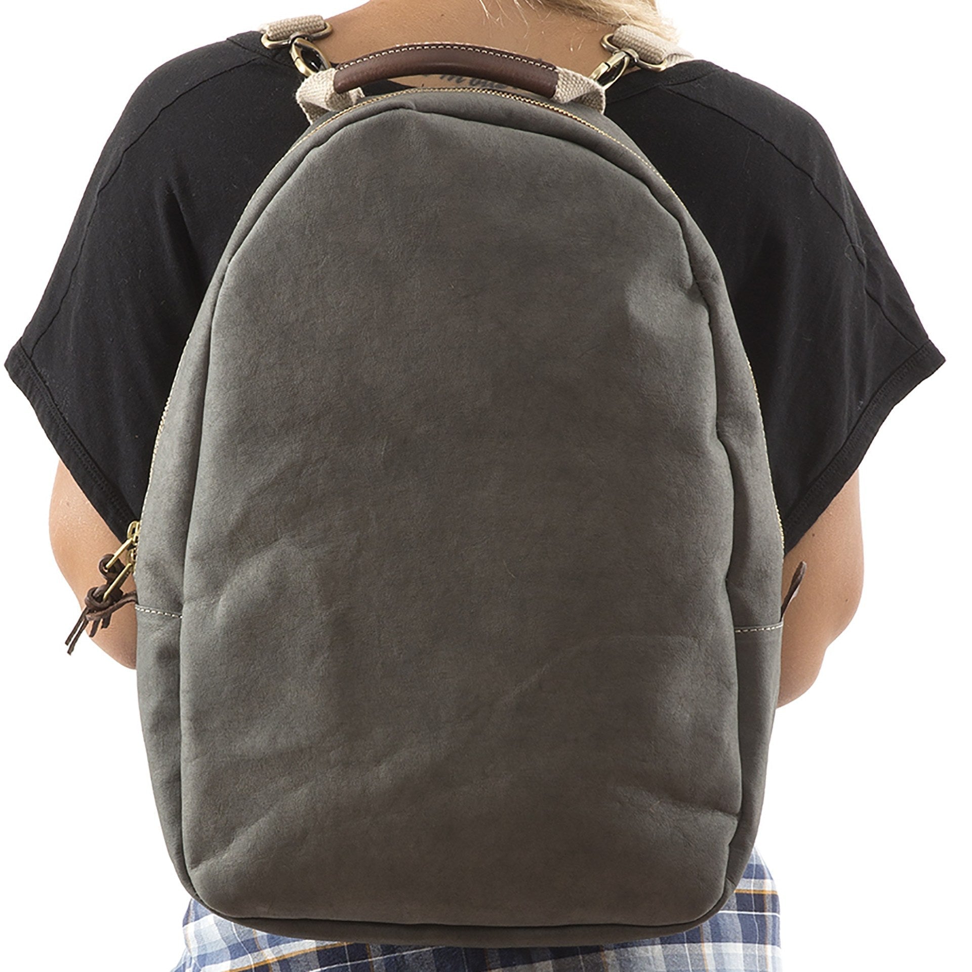 A blonde woman is shown wearing a washable paper backpack. It has two side zip toggles, is oval in shape and it is grey in colour.