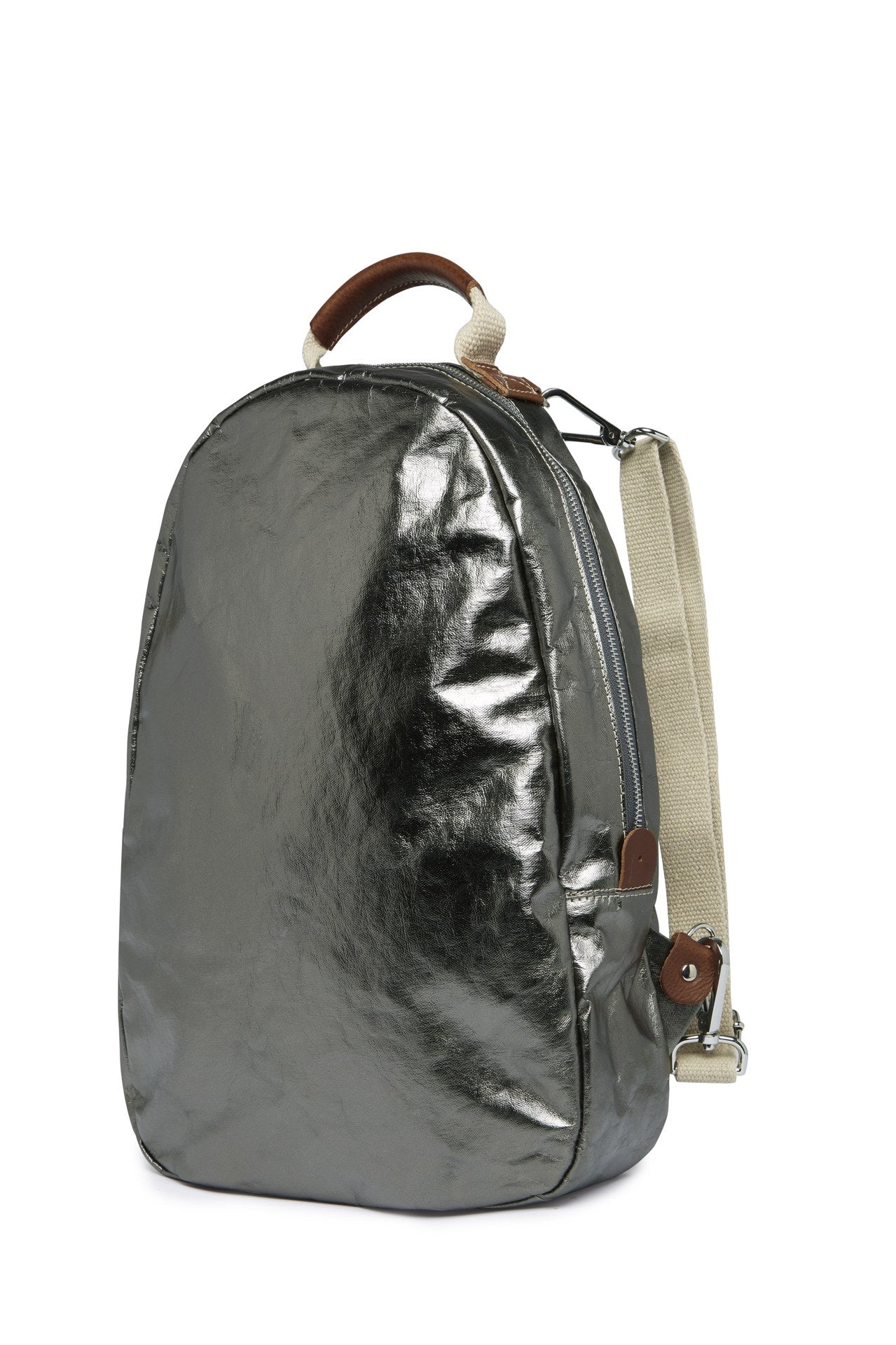 An oval washable paper backpack is shown from a 3/4 angle. It has a top handle, two adjustable canvas shoulder straps, and is metallic pewter in colour.