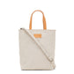 A washable paper rectangular tote with long top handles and a long shoulder strap is shown from the front angle. It is cream in colour.