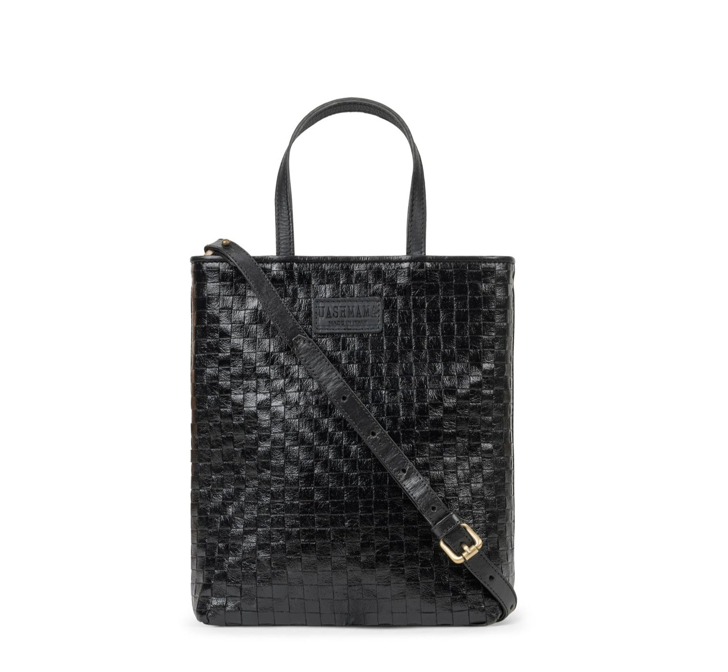 A woven washable paper tote bag is shown from the front angle. It has two top handles and a long shoulder strap. It is black in colour.