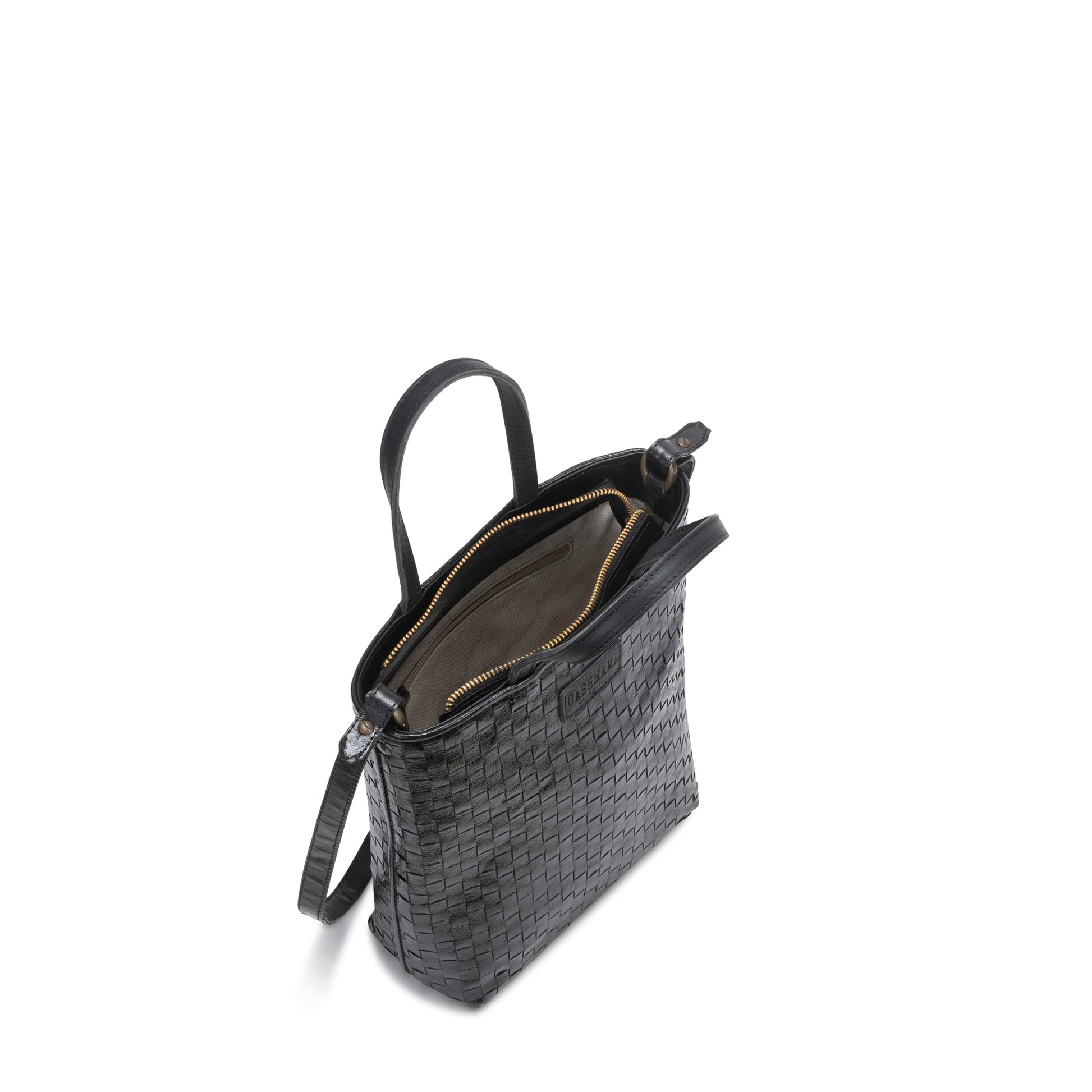 A woven washable paper tote bag is shown from a top-down angle, unzipped to reveal an inside zip pocket. It is black in colour. 