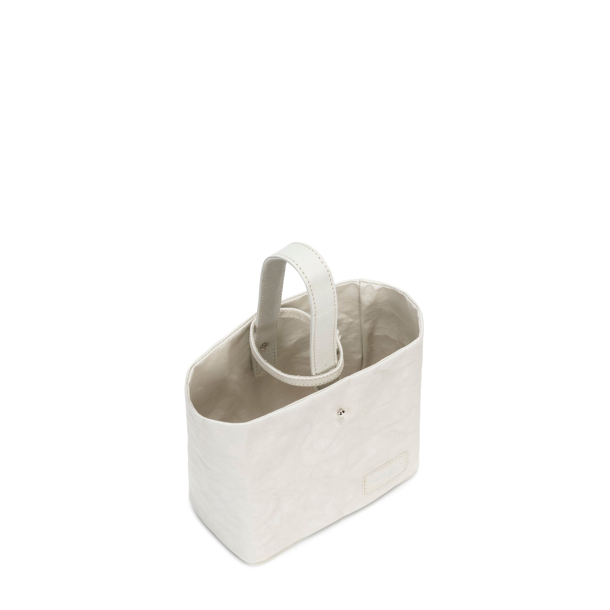 A washable paper utensil holder is shown from a top down angle. It features a top handle and a cotton lining, and it is cream in colour. 