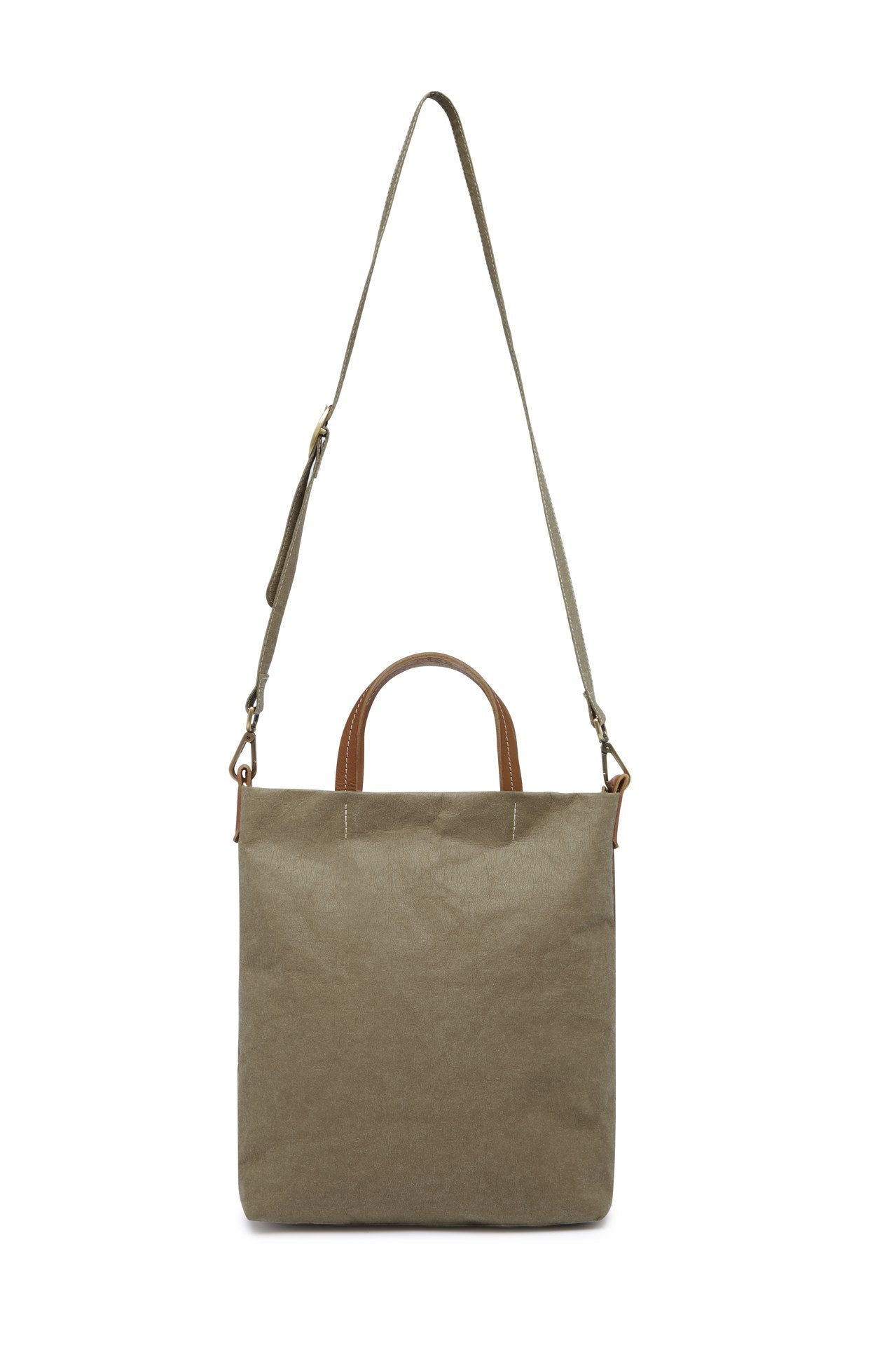 A washable paper tote is shown with a long shoulder strap pointing skywards. It has two top handles and is khaki in colour.