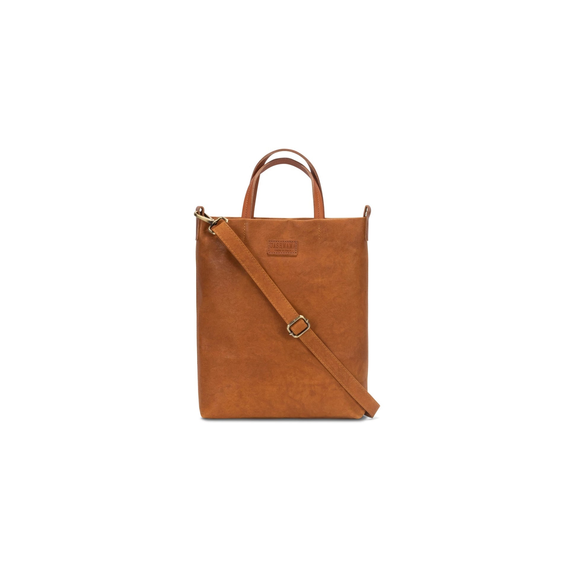 A washable paper tote bag is shown from the front angle. It has a relaxed shape, two top handles and a long shoulder strap. It is rich tan in colour.