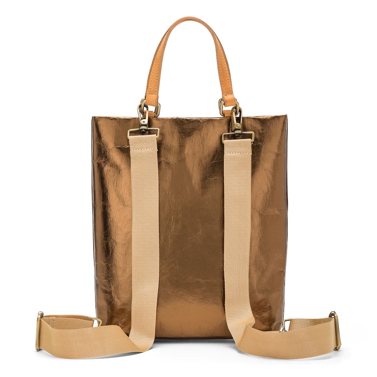 A rectangular tote bag backpack is shown from the back angle. It features two top tote handles, and two adjustable canvas shoulder straps. It is metallic bronze in colour.