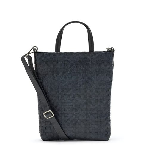 A woven washable paper tote bag is shown from the front angle. It features two top handles and a long adjustable shoulder strap. It is navy in colour.