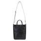 A washable paper tote bag is shown with a long shoulder strap and two top handles. The fabric is woven and it is black in colour.