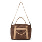 A large washable paper shopper bag is shown from a front angle. It features a long canvas shoulder strap and two top handles. It has an external pocket running the length of the bag, and the UASHMAMA logo stamped in the front. It is shown in a chocolate brown colour. 