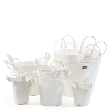 A selection of washable paper baskets are shown stacked in one another, in four varying sizes. They are shown in a white colour.
