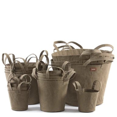 A selection of washable paper baskets are shown stacked in one another, in four varying sizes. They are shown in a sand colour.