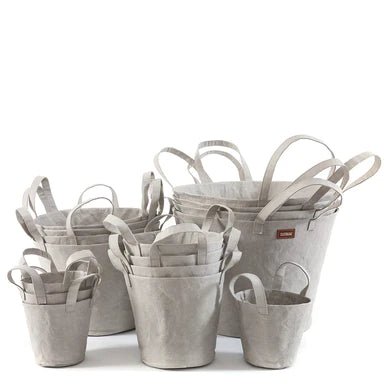 A selection of washable paper baskets are shown stacked in one another, in four varying sizes. They are shown pale grey in colour.