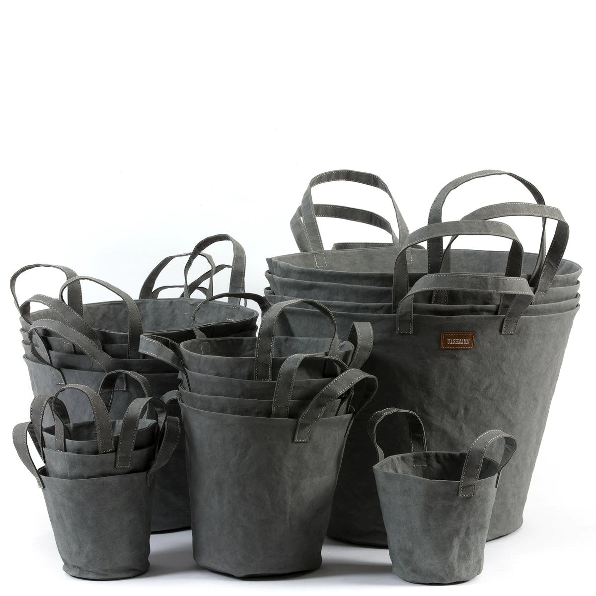 A selection of washable paper baskets are shown stacked in one another, in four varying sizes. They are shown in a dark grey colour.