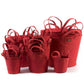 A selection of washable paper baskets are shown stacked in one another, in four varying sizes. They are shown in a red colour.