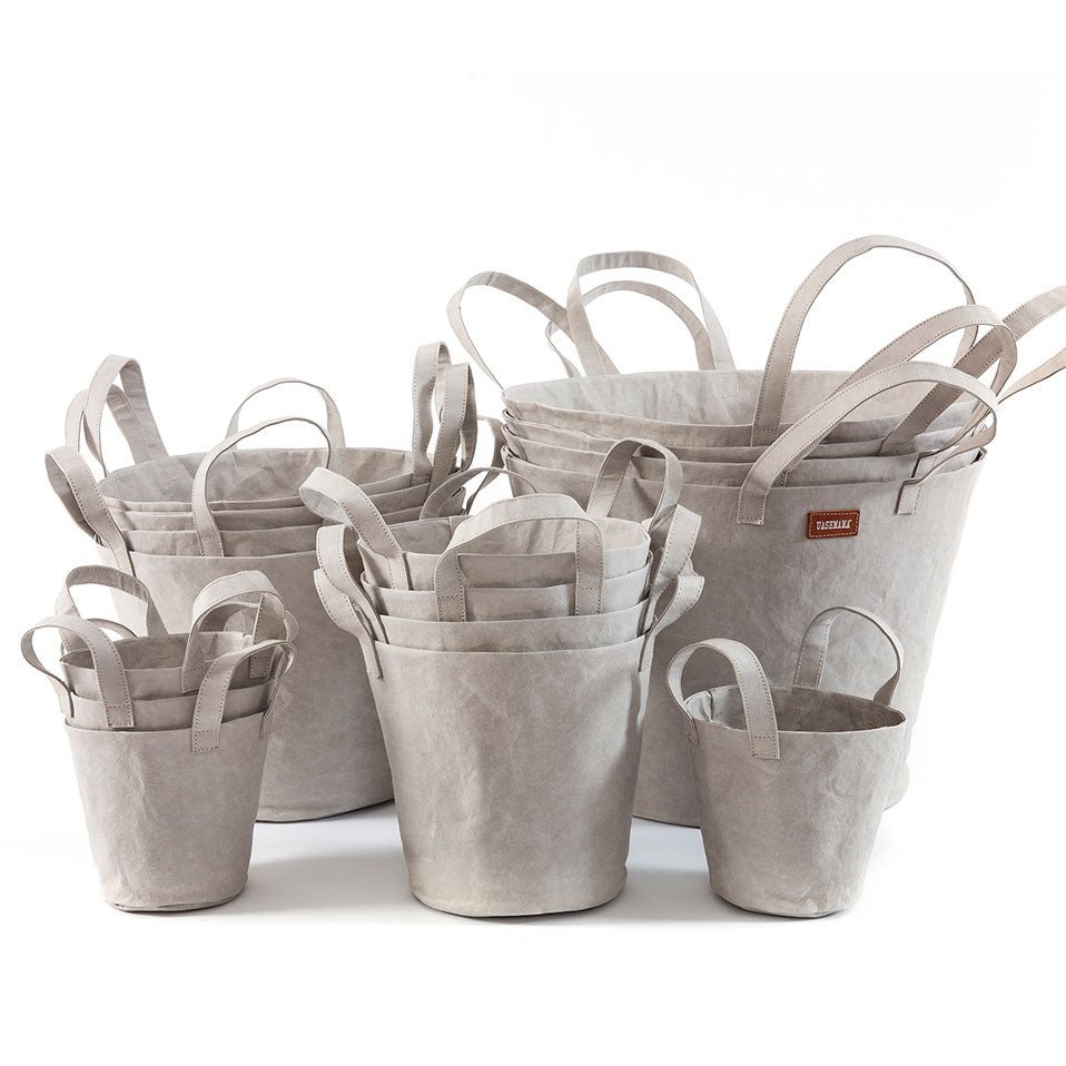 A selection of washable paper baskets are shown stacked in one another, in four varying sizes. They are shown in a pale grey colour.