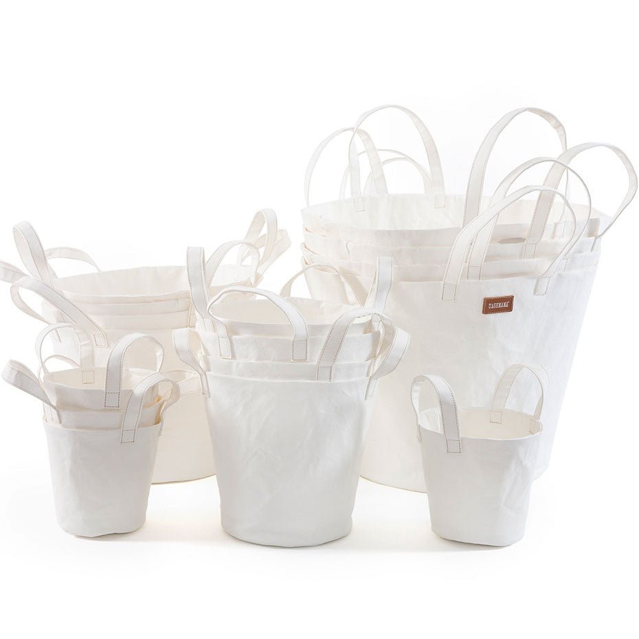 A selection of washable paper baskets are shown stacked in one another, in four varying sizes. They are shown in a white colour. 