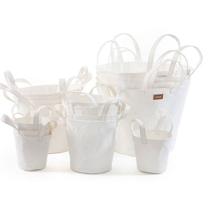 A selection of washable paper baskets are shown stacked in one another, in four varying sizes. They are shown in a white colour. 