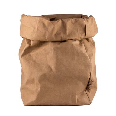 A washable paper bag is shown. The bag is rolled down at the top and features a UASHMAMA logo label on the bottom left corner. The bag pictured is the extra extra large size in tan.