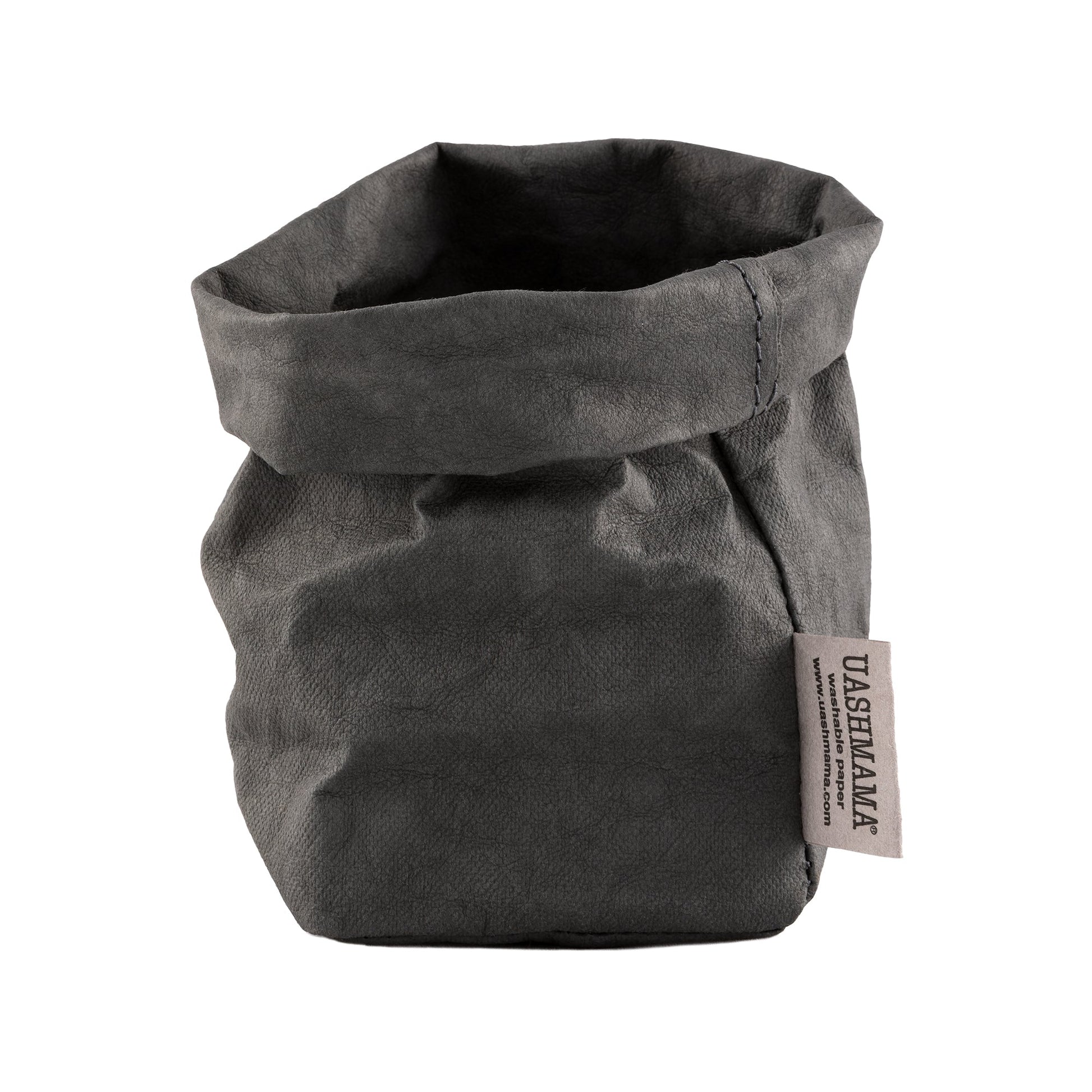 A washable paper bag is shown. The bag is rolled down at the top and features a UASHMAMA logo label on the bottom left corner. The bag pictured is the piccolo size in dark grey.