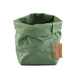 A washable paper bag is shown. The bag is rolled down at the top and features a UASHMAMA logo label on the bottom left corner. The bag pictured is the piccolo size in green.