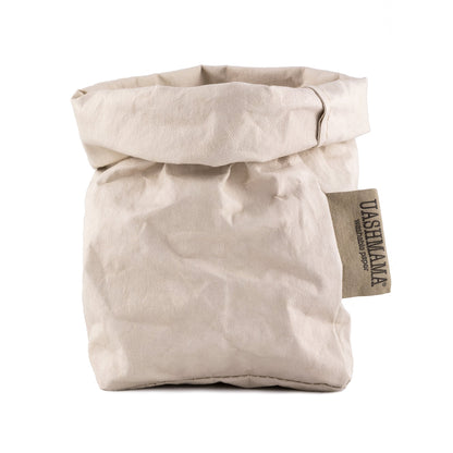 A washable paper bag is shown. The bag is rolled down at the top and features a UASHMAMA logo label on the bottom left corner. The bag pictured is the small size in a cream colour.