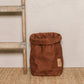A washable paper bag is shown. The bag is rolled down at the top and features a UASHMAMA logo label on the bottom left corner. The bag pictured is the extra large size in brown. Next to the paper bag is a wooden ladder.