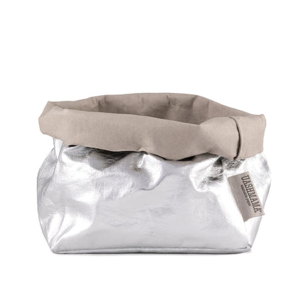 A washable paper bag is shown. The bag is rolled down at the top and features a UASHMAMA logo label on the bottom left corner. The bag pictured is the large size in metallic silver.