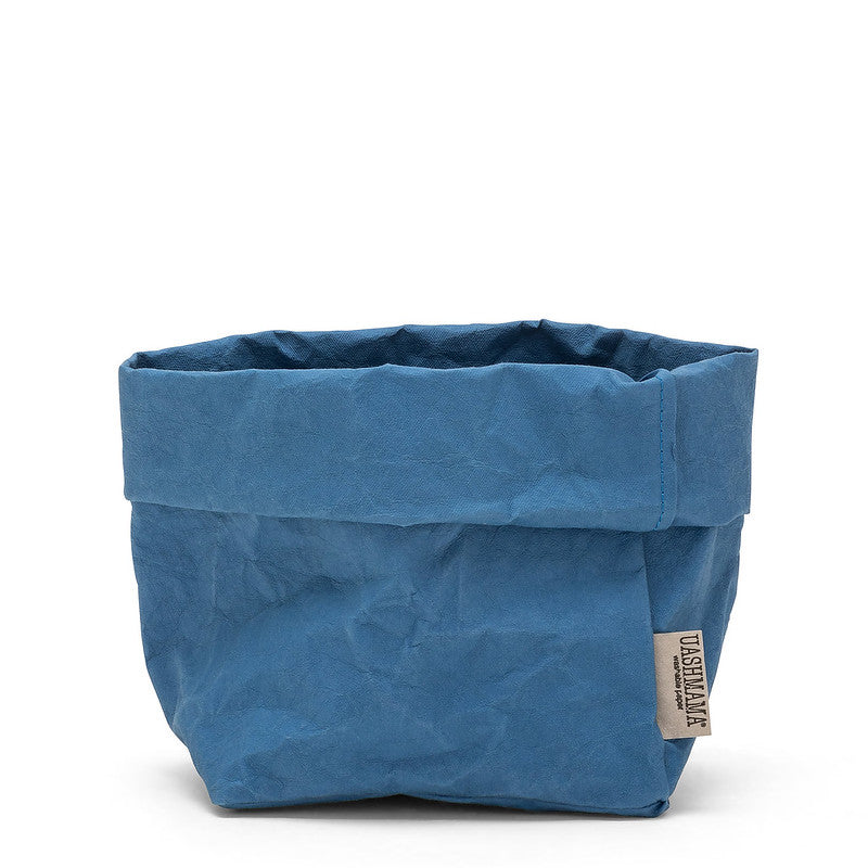 A medium paper bag in denim blue colour. The top is rolled down.