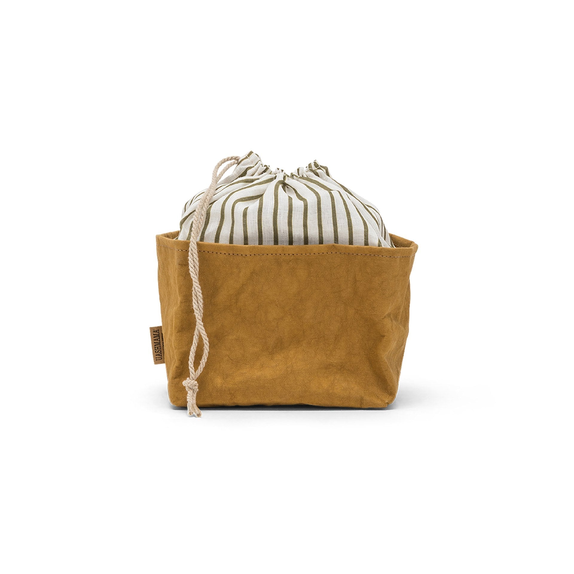 A washable paper bread bag with a drawstring organic linen top is shown. The bag has a small UASHMAMA logo label on the left hand side and fastens with a beige cord drawstring. The bag is tan in colour with an olive and cream cotton drawstring top.