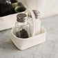 A small rectangular washable paper salt and pepper holder is shown with a washable paper small carry handle. The salt and pepper holder shown is white and is shown holding small glass salt and pepper shakers with metal lids.