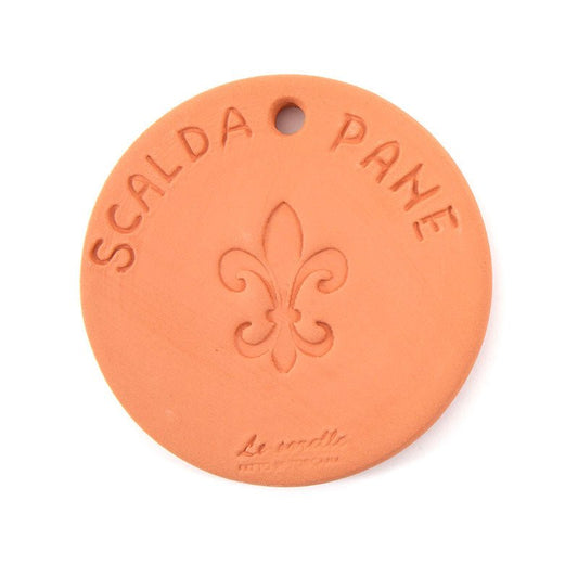 A round terracotta tile is shown with the words Scalda Pane etched into the surface. 