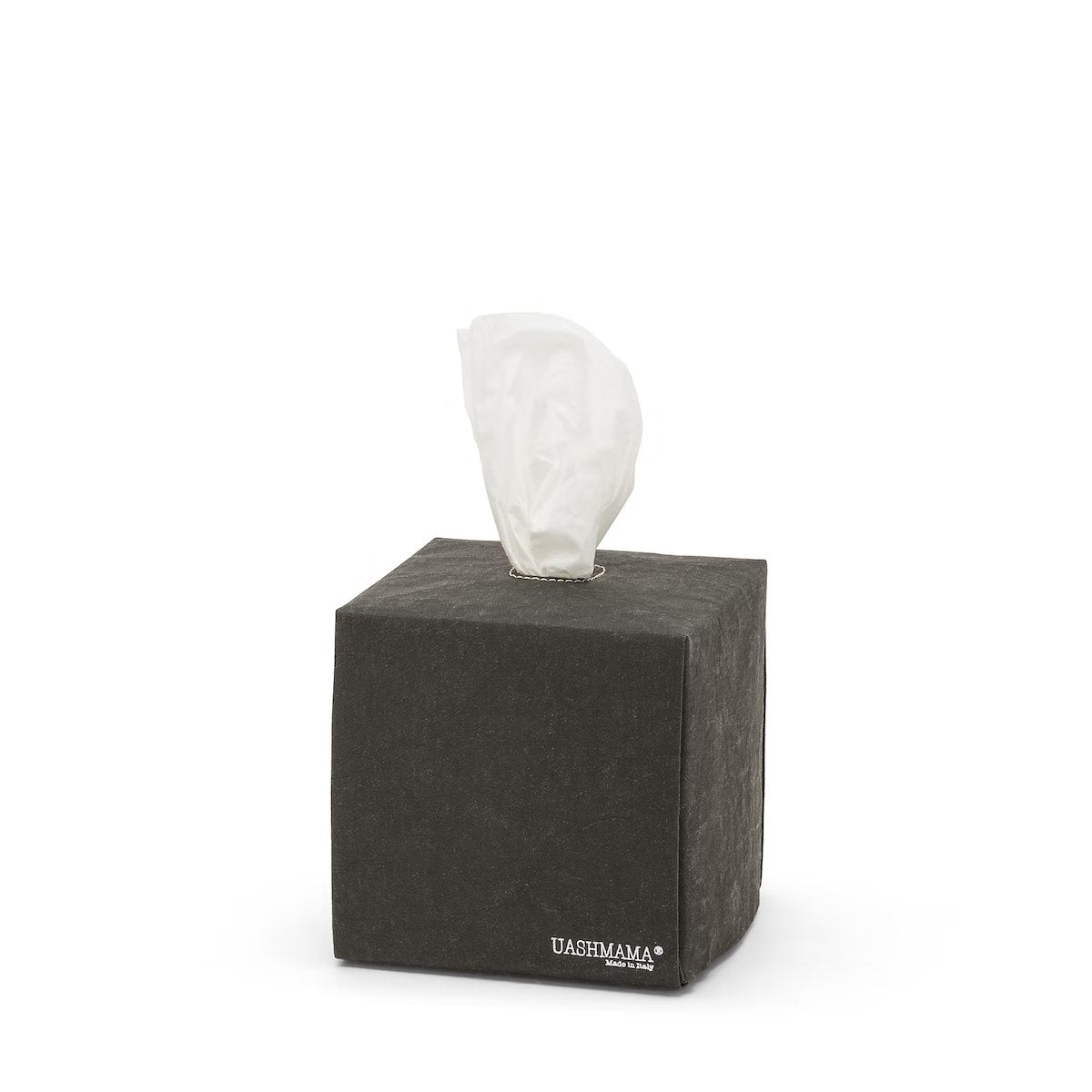 A square tissue box holder made of washable paper is shown, with a white tissue protruding from the top of the box. The UASHMAMA logo is printed in white lettering on the bottom right hand corner of the box. The tissue box cover is black.