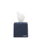 A square tissue box holder made of washable paper is shown, with a white tissue protruding from the top of the box. The UASHMAMA logo is printed in white lettering on the bottom right hand corner of the box. The tissue box cover is dark blue.