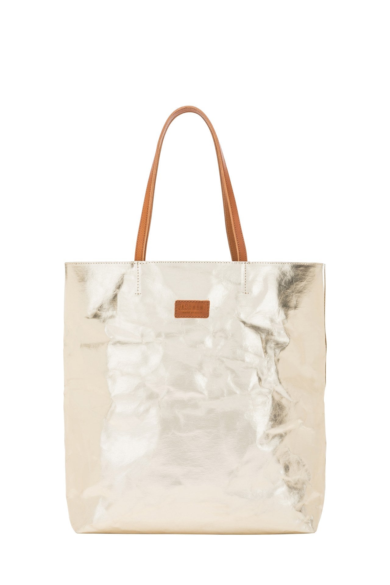 A washable paper tote back is shown. It has two long leather handles and small leather UASHMAMA label on the front. It is shown in a metallic platinum colour with tan handles and label.