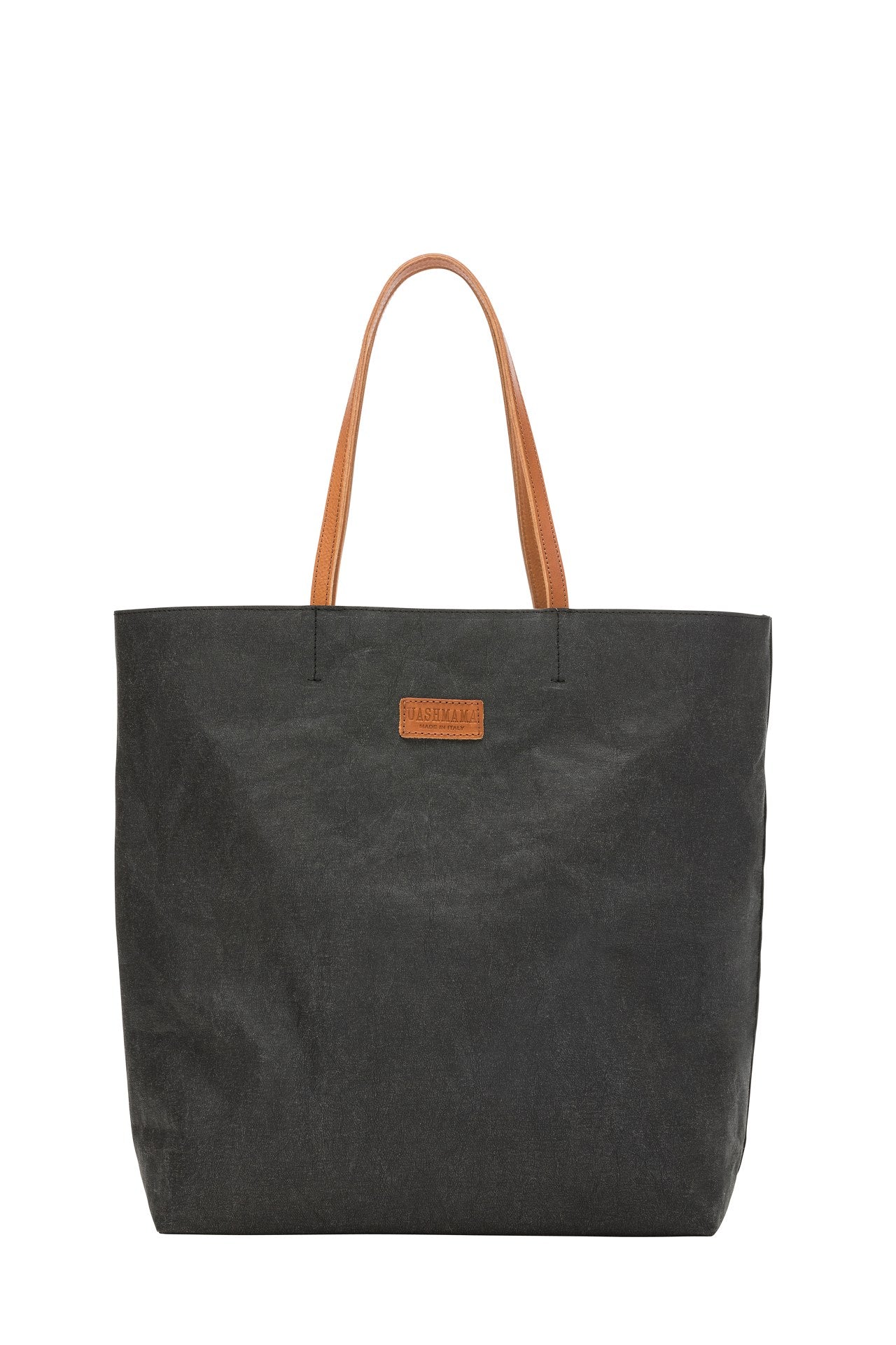 A washable paper tote back is shown. It has two long leather handles and small leather UASHMAMA label on the front. It is shown in black with tan handles and label.