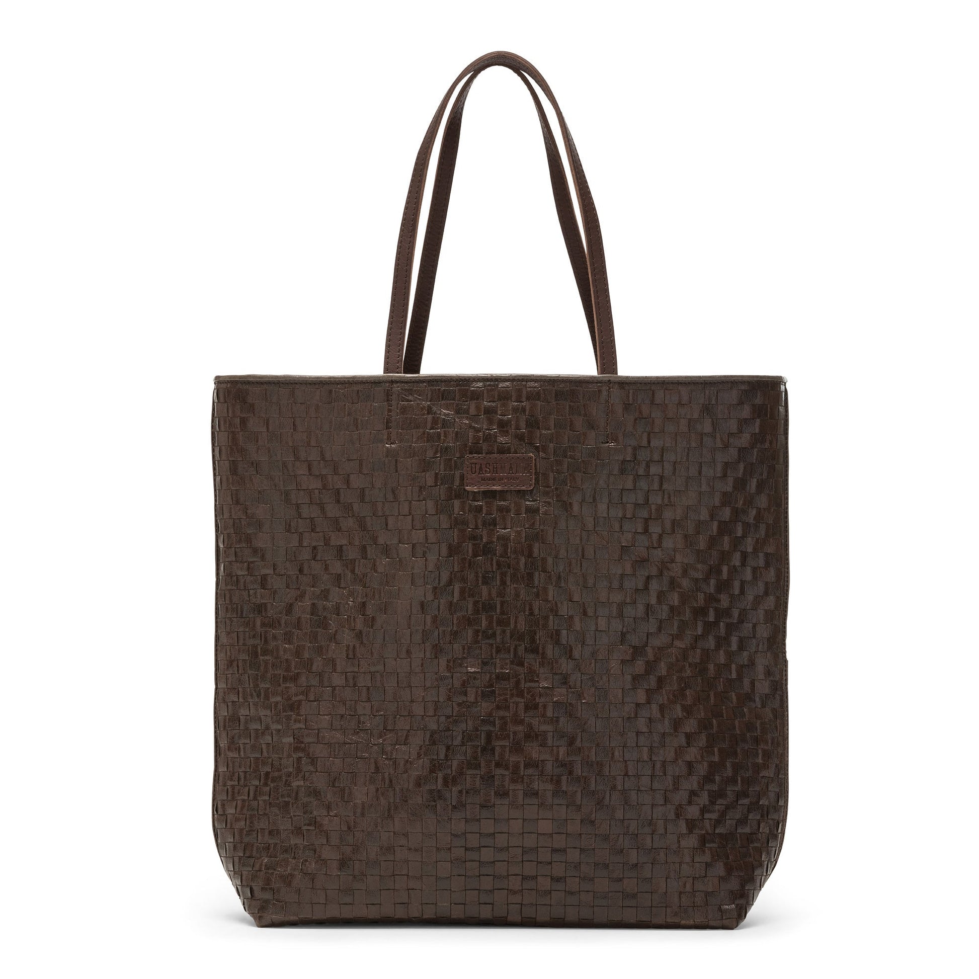 A woven washable paper tote bag is shown. It has two long leather handles and small leather UASHMAMA label on the front. It is shown in a dark brown colour.