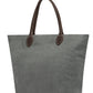 A large washable paper tote is shown. It has two long brown leather handles. The bag shown is in a dark grey colour.
