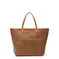 A large washable paper woven tote is shown. It has two long tan leather handles and a tan leather UASHMAMA logo label on the outside in between the handles. The bag shown is in a dark tan colour.