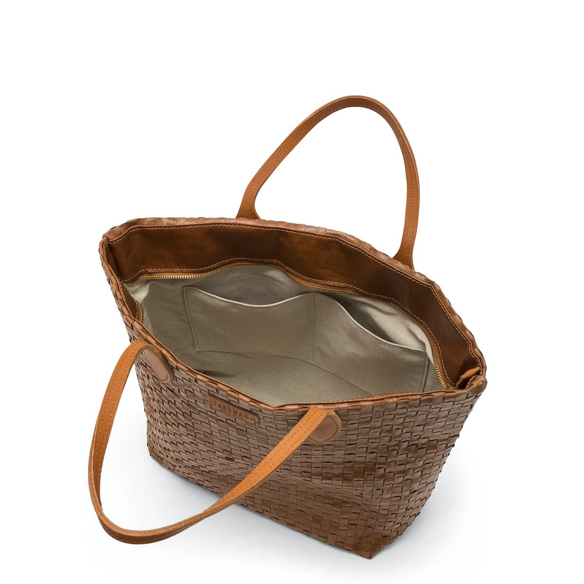 A large washable paper woven tote is shown open and showing the interior. The interior shows an organic cotton lining and two small interior pockets. The bag closes with a zip. It has two long tan leather handles and a tan leather UASHMAMA logo label on the outside in between the handles. The bag shown is in a dark tan colour.